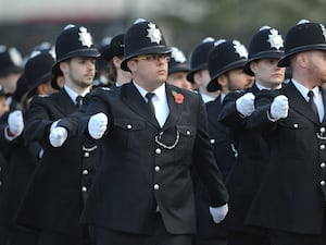 Uniformed Metropolitan Police officers marching during a passing out parade.