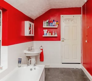 The bathroom features a bright red colour