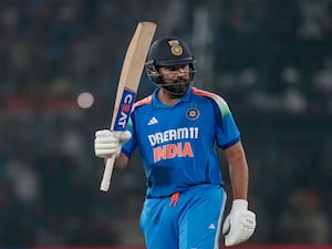 Rohit Sharma raises his bat in celebration of his hundred