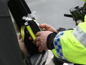 A police officer looking at a breathalyser