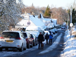 People walk along a snowy road