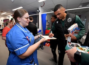  Walsall FC players met staff and patients at Walsall Manor Hospital and gave presents out for Christmas. out. Defender David Okagbue signs an autograph for a hard working nurse