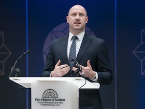 Neil Gray speaking from a lectern