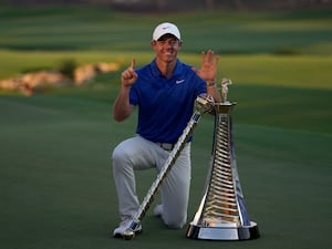 Rory McIlroy of Northern Ireland poses with the DP World Tour Championship trophy and the Race to Dubai trophy