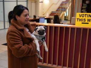 Sonia Higgins, carrying her dog Chico, arrives to cast her vote in Ireland's General Election