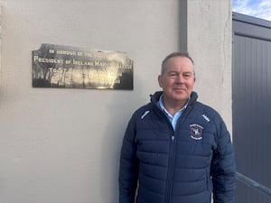 Alan MacNeice next to a sign outside St Brigid's club in Kiltoom