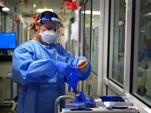 A nurse putting on protective clothing in the COVID-19 pandemic