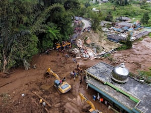 Rescuers use heavy machinery to search for victims after a landslide in Karo, North Sumatra, Indonesia