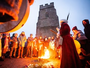 People take part in the winter solstice celebrations during sunrise at Glastonbury Tor in Somerset