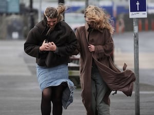 Two young women struggling against a strong wind