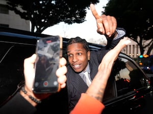 ASAP Rocky gestures out of the window of a vehicle while leaving court after he was found not guilty in his trial