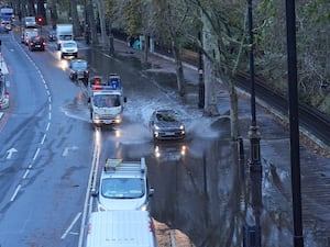 Vehicles drive through floodwater on Victoria Embankment in central London