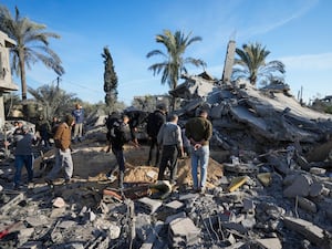 Palestinians look at a home destroyed by an Israeli strike in Deir al-Balah