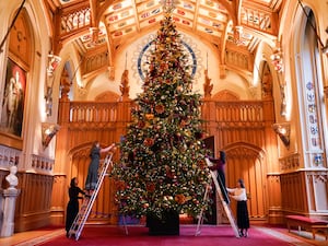 Royal Collection Trust staff add the finishing touches to a Christmas tree in St George’s Hall, Windsor Castle