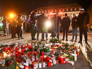 People lay flowers in the cathedral square of Magdeburg