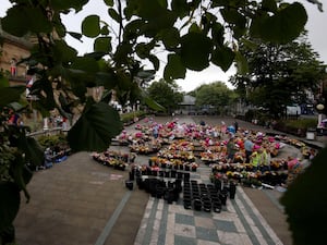 Members of the public look at floral tribute left outside Southport Town Hall