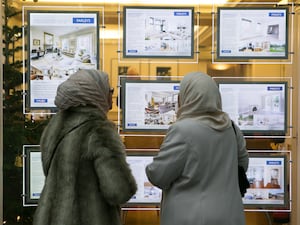 People looking in an estate agent's window