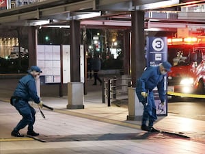 Members of police examine the scene of a knife attack in Nagano, Japan