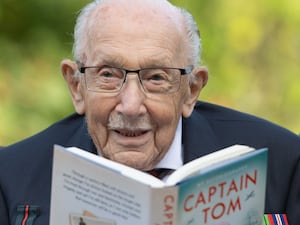 Captain Sir Tom Moore holding a book