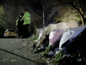 Flowers left at the scene on Ravenscraig Road near Ashtons Field, Salford, in Greater Manchester, where the remains of a baby were found in a field