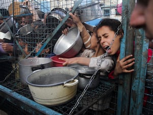 Palestinians line up to receive free meals at Jabaliya refugee camp in the Gaza Strip