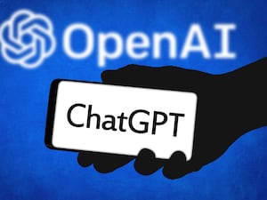 A hand holding a mobile saying ChatGPT with the OpenAI logo in the background