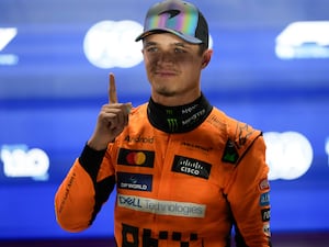 McLaren driver Lando Norris celebrates after taking pole position for the sprint race in Qatar