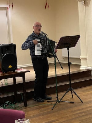 Dr Richard Churchley accompanying Christmas Songs at the Lodge.