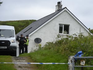 Police officers and police tape outside house