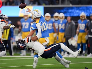 Los Angeles Chargers quarterback Justin Herbert is tackled as he throws by Denver Broncos linebacker Jonathon Cooper