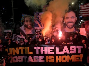 Demonstrators light flares as they gather during a protest calling for the release of all hostages held captive by Hamas in the Gaza Strip, in Tel Aviv