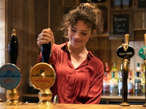 A barmaid pulls a pint of Young's beer