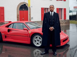 Lewis Hamilton in front of a Ferrari car at Maranello