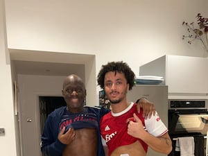 Father and son lifting their shirts up with white patches on their stomach following a kidney donation operation