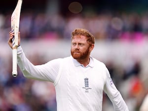 Jonny Bairstow holds his bat up with his right hand