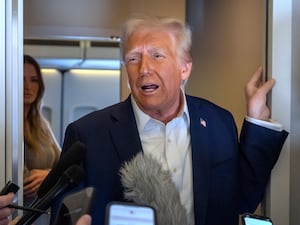 US President Donald Trump speaks to reporters aboard Air Force One