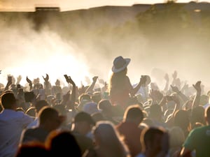 Large group of music fans, some with arms raised