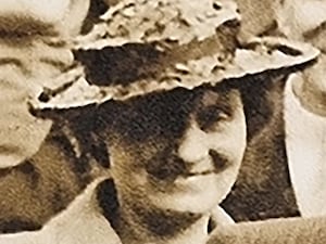 Black and white headshot of a woman wearing a hat