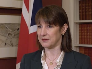 Rachel Reeves standing in front of a Union Flag and a bookshelf