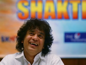 Indian Tabla musician Zakir Hussain laughs during a press conference to announce a musical concert in Mumbai, India