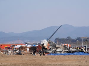 Firefighters and rescue team members work near the wreckage of the passenger plane at Muan International Airport