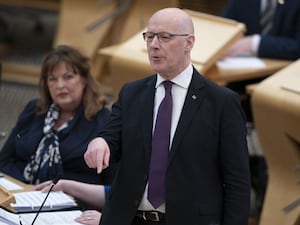 John Swinney standing while speaking in Holyrood