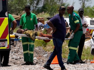 A miner is transported on a stretcher by rescue workers