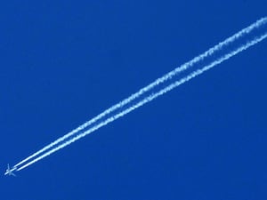 A white stripe in the sky from a plane, known as a contrail