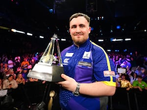 Luke Littler holds the Premier League trophy