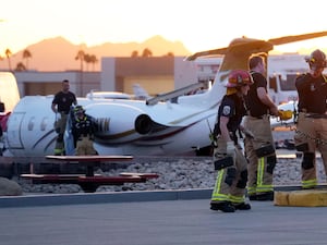 Scottsdale Fire Department firefighters work on a crashed Learjet at Scottsdale Airport