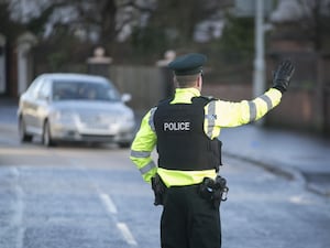 A police officer signals to a car on a road