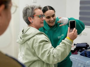 Emily Damari, right, and her mother Mandy use a smartphone near kibbutz Reim, southern Israel, after Emily was released from captivity by Hamas militants in Gaza