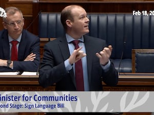 Stormont Communities Minister Gordon Lyons communicating in sign language in the Northern Ireland Assembly chamber