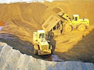 Wheelloaders transport iron ore at an ore yard in China